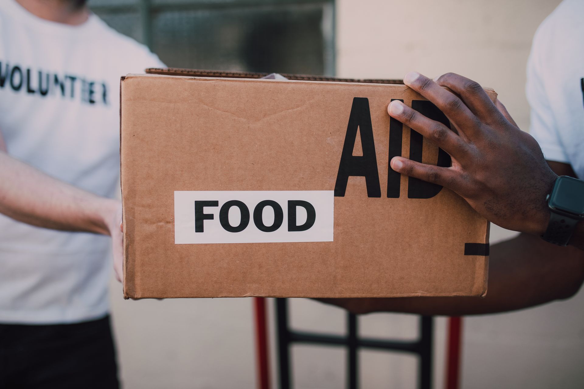 Volunteers handing over a box of food supplies